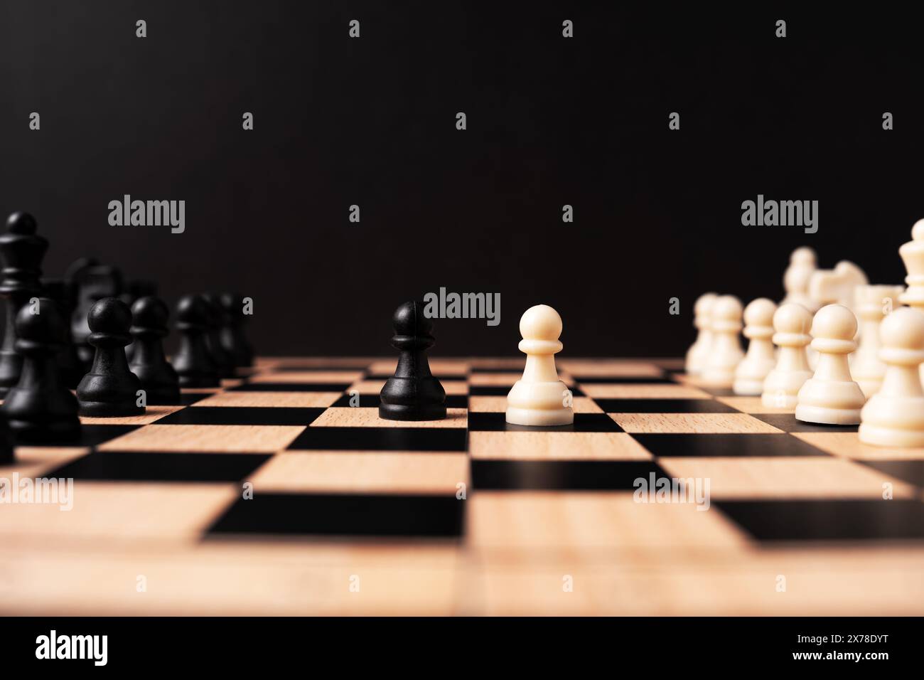Face d'échecs de pion blanc off avec fond noir d'échecs de pion noir Banque D'Images
