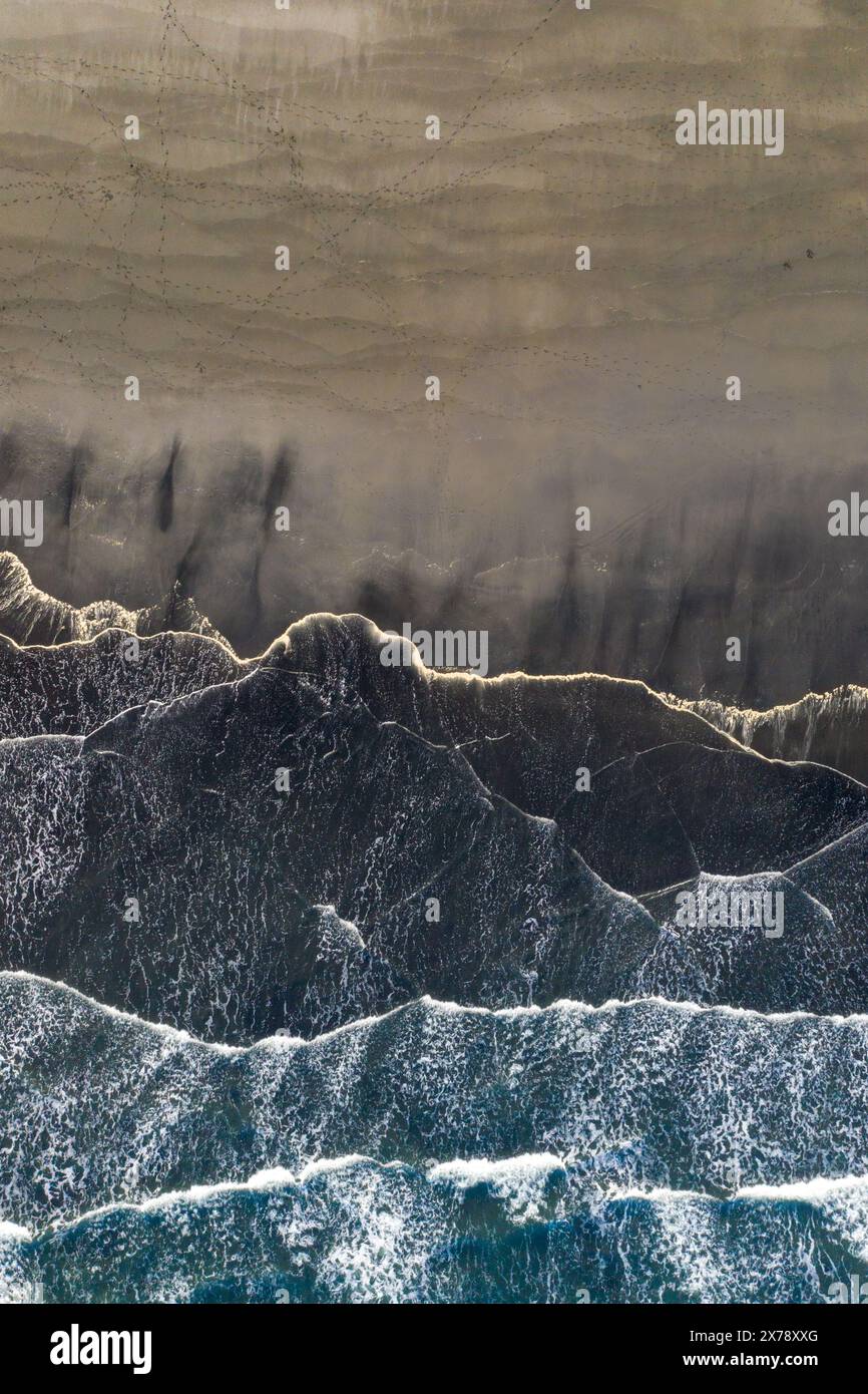 Vue aérienne des vagues et des motifs sur la plage de sable noir de Stokksnes, sud-est de l'Islande Banque D'Images