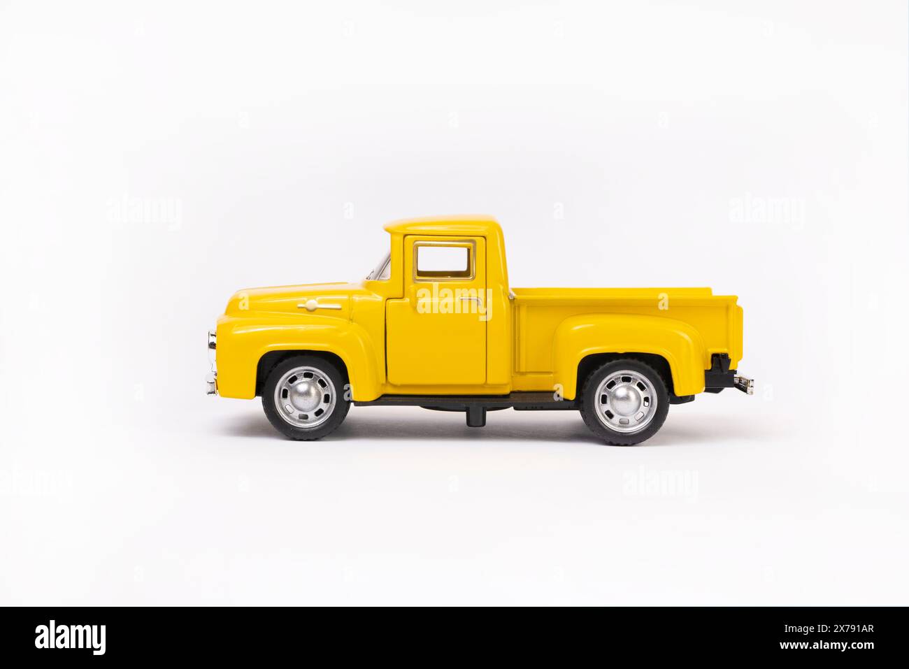 voiture jouet miniature de couleur jaune isolé sur fond blanc. camionnette rétro. Banque D'Images