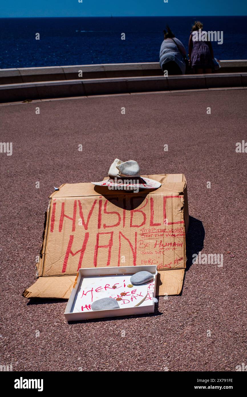 La sculpture de rue de l'homme invisible de la vie - un chapeau vide et une boîte à monnaie - humour. Langue française et anglaise. Nice, Provence, France. Humoristique.. Banque D'Images