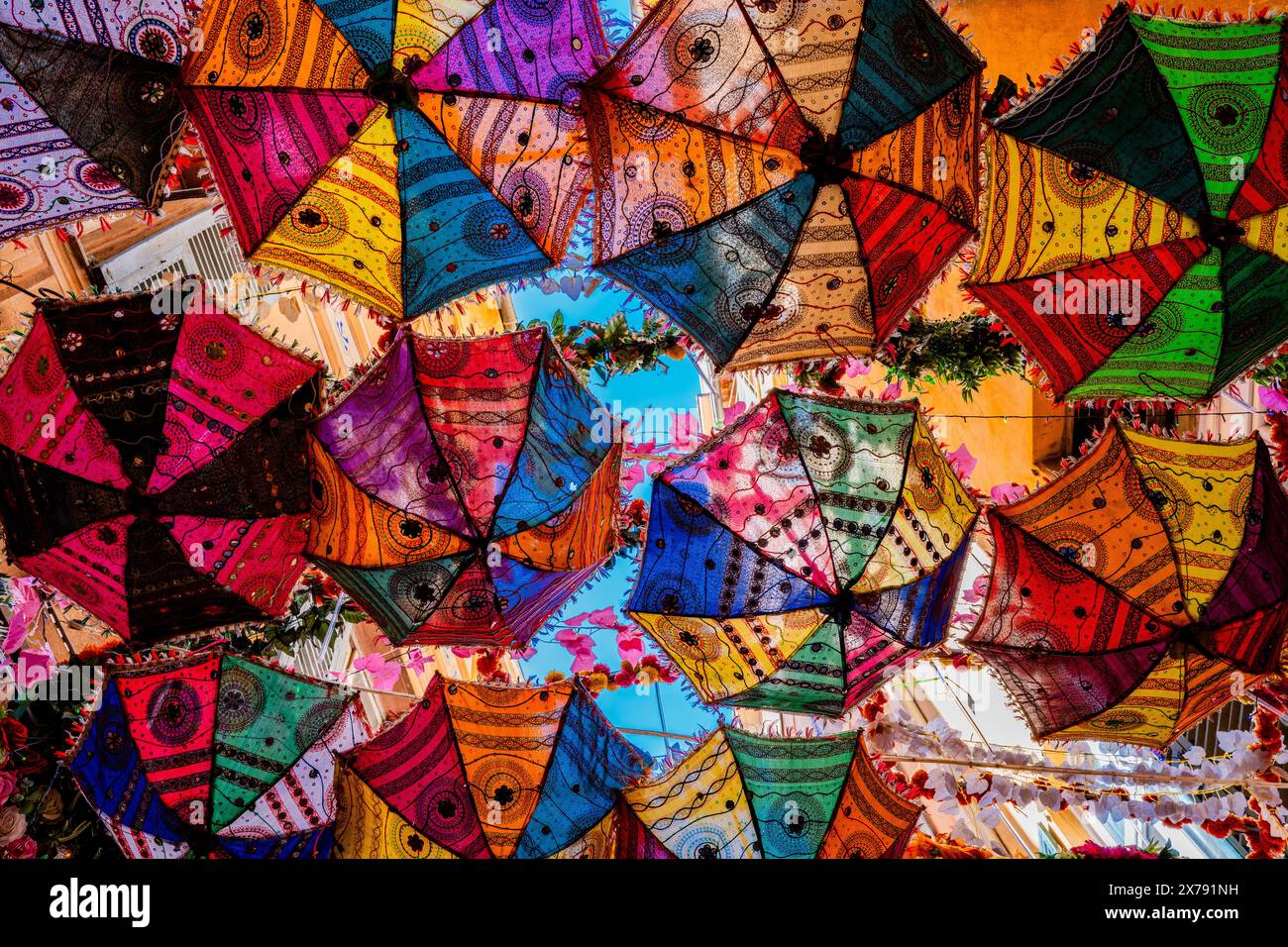 Nice, France - des parasols colorés suspendus à l'envers au-dessus d'une rue étroite fournissent de l'ombre sur les tables de l'un des restaurants en plein air Banque D'Images