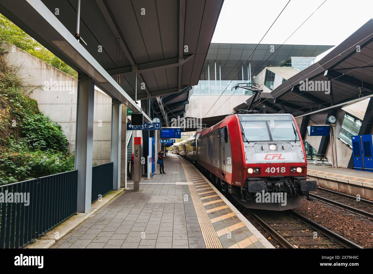 Un train CFL arrive au quai de la gare de Pfaffenthal-Kirchberg, Luxembourg, avec des auvent et des quais élégants, pendant que les passagers attendent Banque D'Images