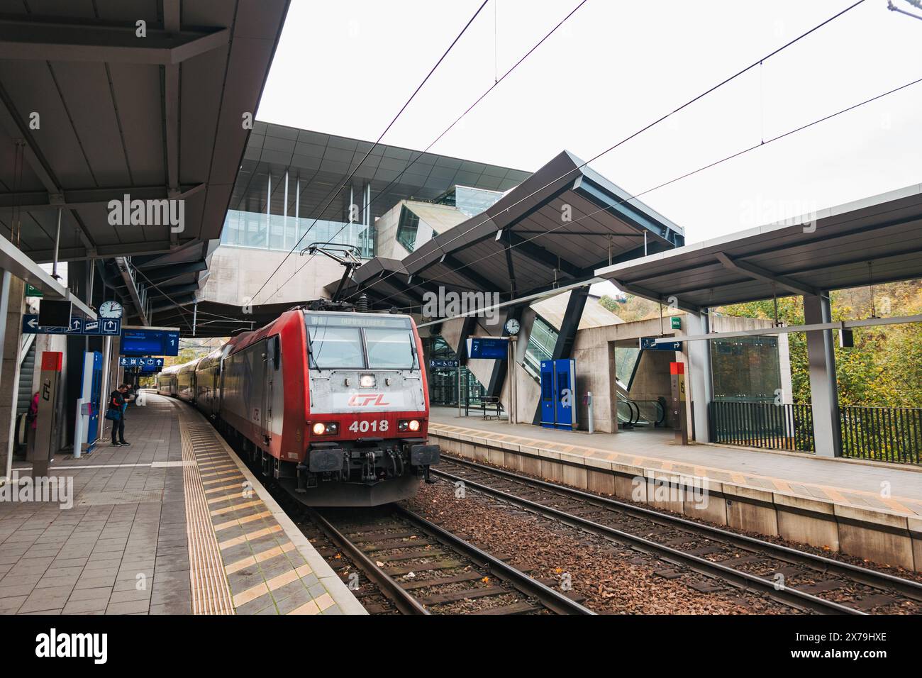 Un train CFL arrive au quai de la gare de Pfaffenthal-Kirchberg, Luxembourg, avec des auvent et des quais élégants, pendant que les passagers attendent Banque D'Images