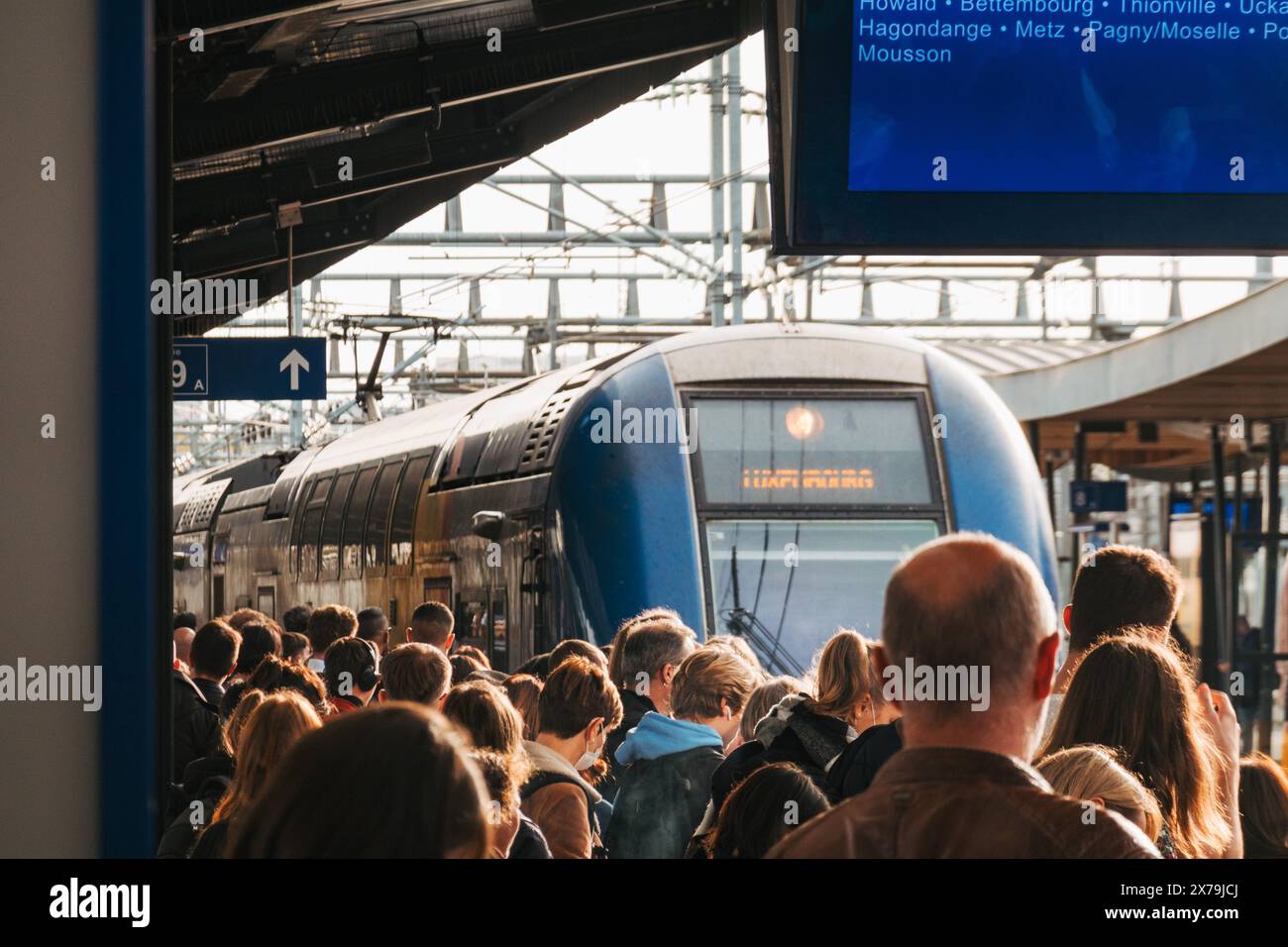 Un train arrive sur un quai bondé à la gare de Luxembourg en fin d'après-midi Banque D'Images