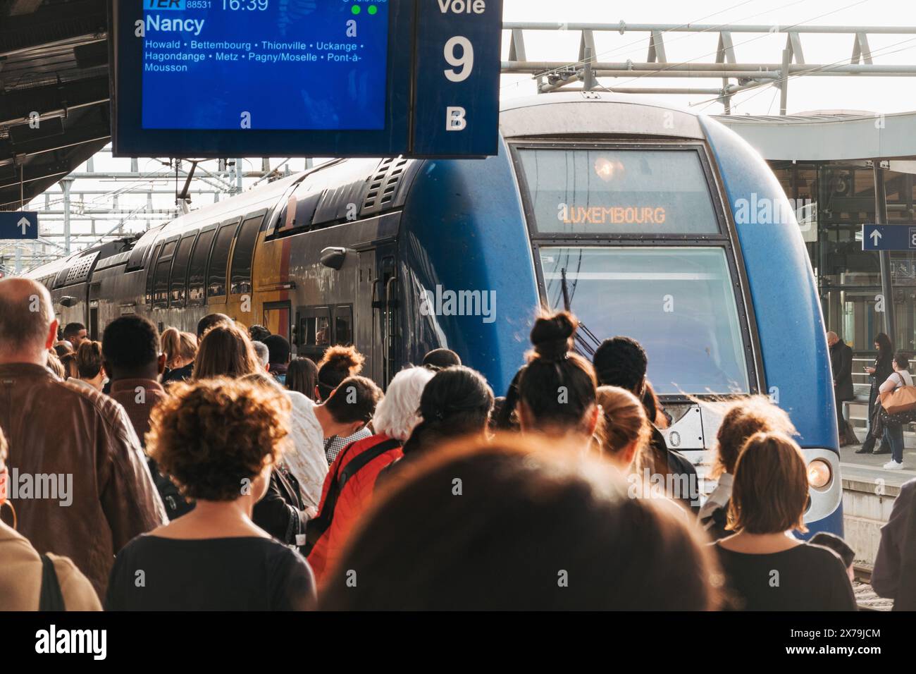 Un train arrive sur un quai bondé à la gare de Luxembourg en fin d'après-midi Banque D'Images