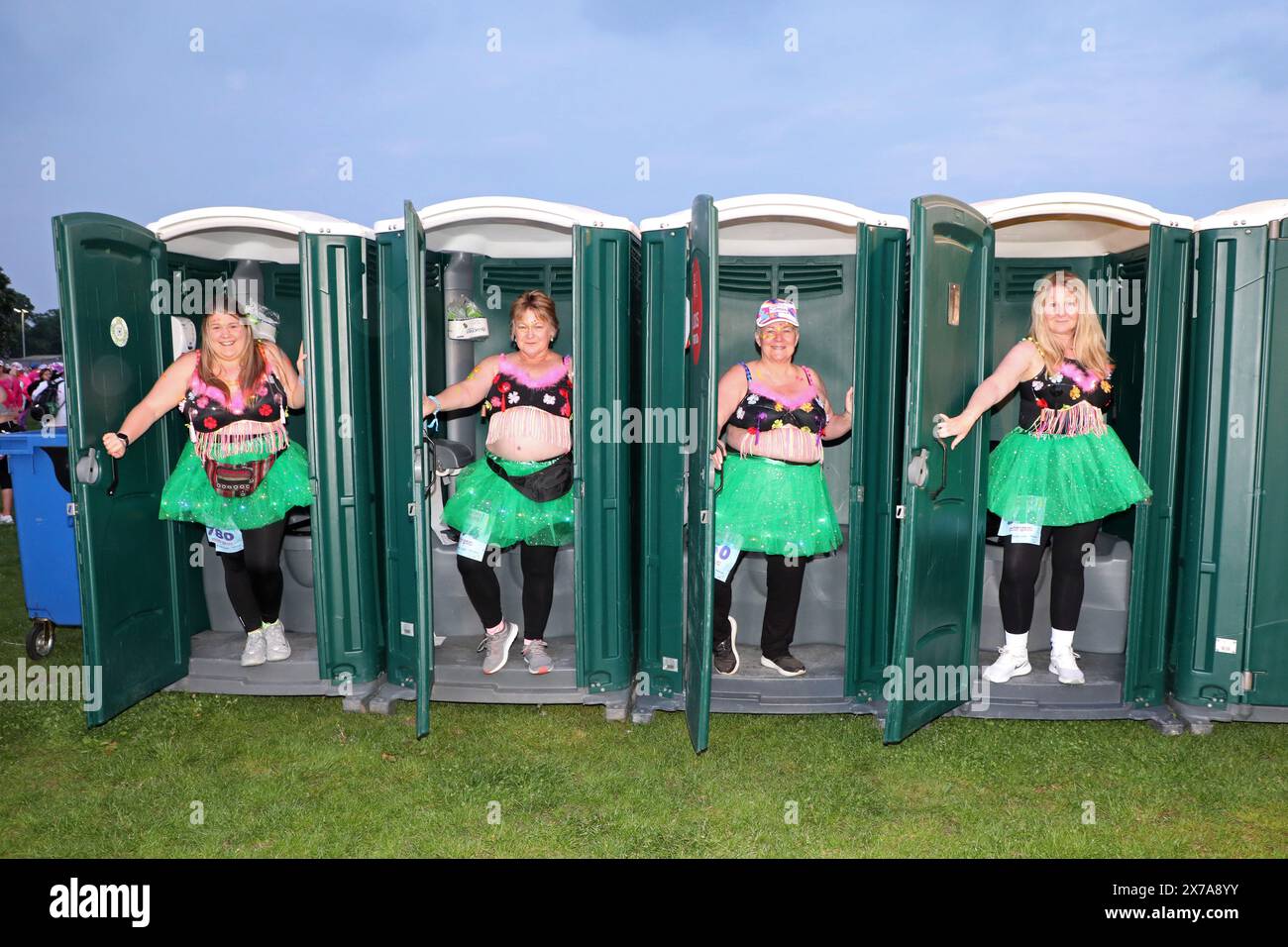 Londres, Royaume-Uni. 18 mai 2024. Les participants utilisant des portaloos portant des soutiens-gorge décorés prennent part au marathon Walk the Walk Moonwalk à Londres afin de recueillir des fonds pour l'organisme caritatif de lutte contre le cancer du sein. Cette année, le thème est Fiesta, et les participants traversent le centre de Londres pendant la nuit en passant par la plupart des monuments célèbres, dont beaucoup étaient illuminés en rose pour l'événement. Pour plus d'informations, voir www.walkthewalk.org crédit : Paul Brown/Alamy Live News Banque D'Images