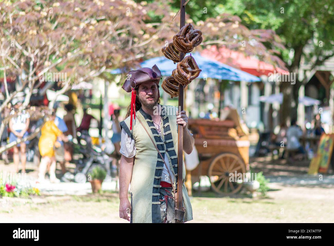 Houston, Texas, États-Unis. 18 mai 2024. Un jeune homme en costume du 16e siècle vend des bretzels au Festival Renaissance de Scarborough à Waxahachie, dans la banlieue de Dallas, Texas, États-Unis, le 18 mai 2024. Crédit : Lin Li/Xinhua/Alamy Live News Banque D'Images