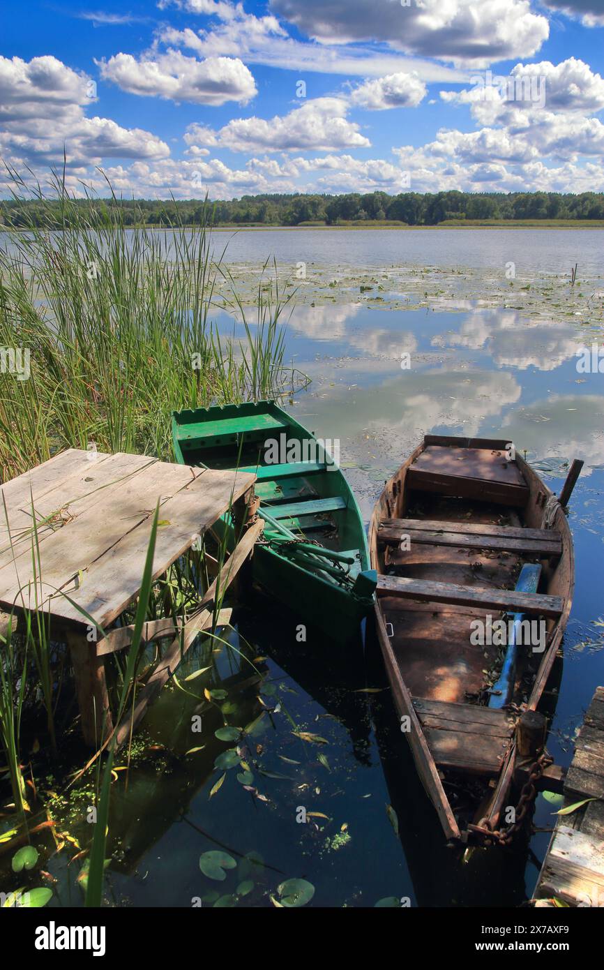 La photo a été prise en Ukraine, sur la rivière Southern Bug. La photo montre un bateau de pêche amarré près de la rive de la rivière sous un ciel bleu avec la lumière CLO Banque D'Images