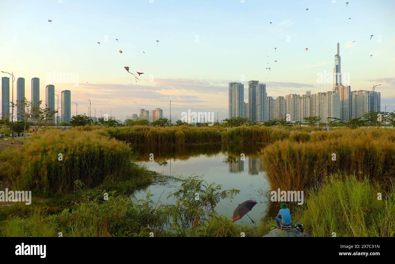 Belle scène à la campagne de Ho Chi Minh ville, homme aller pêcher, se détendre le week-end en volant un cerf-volant, cerfs-volants sur le ciel bleu avec des fleurs de roseaux, Landmark 81 ref Banque D'Images