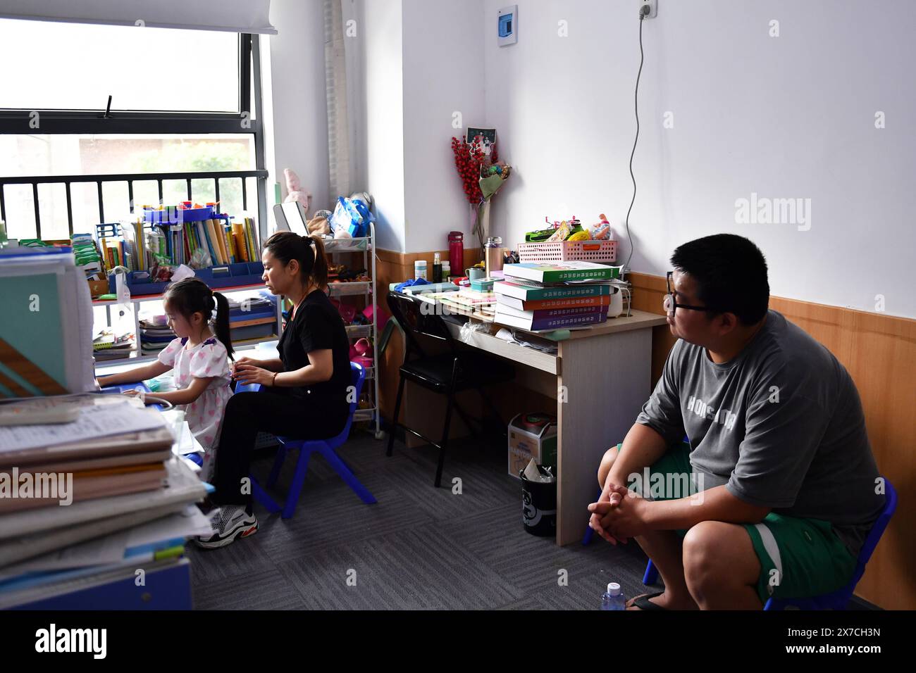 (240519) -- CHANGSHA, 19 mai 2024 (Xinhua) -- sa fille Zhang Yuhan (à gauche) suit un cours accompagné de son père Zhang Yongsheng dans un centre de développement de l'enfant à Changsha, dans la province du Hunan, au centre de la Chine, le 17 mai 2024. Bien que malentendants, Zhang Yongsheng et sa femme Zhan Jingwen ont réussi à faire entendre leur fille, qui souffre également du même handicap, à l'âge de deux ans. En tenant un stand de collation sur un marché nocturne et grâce au soutien de leurs proches et amis, le couple a réussi à se procurer un implant cochléaire pour l'oreille gauche de sa fille et une prothèse auditive pour celle de sa fille Banque D'Images