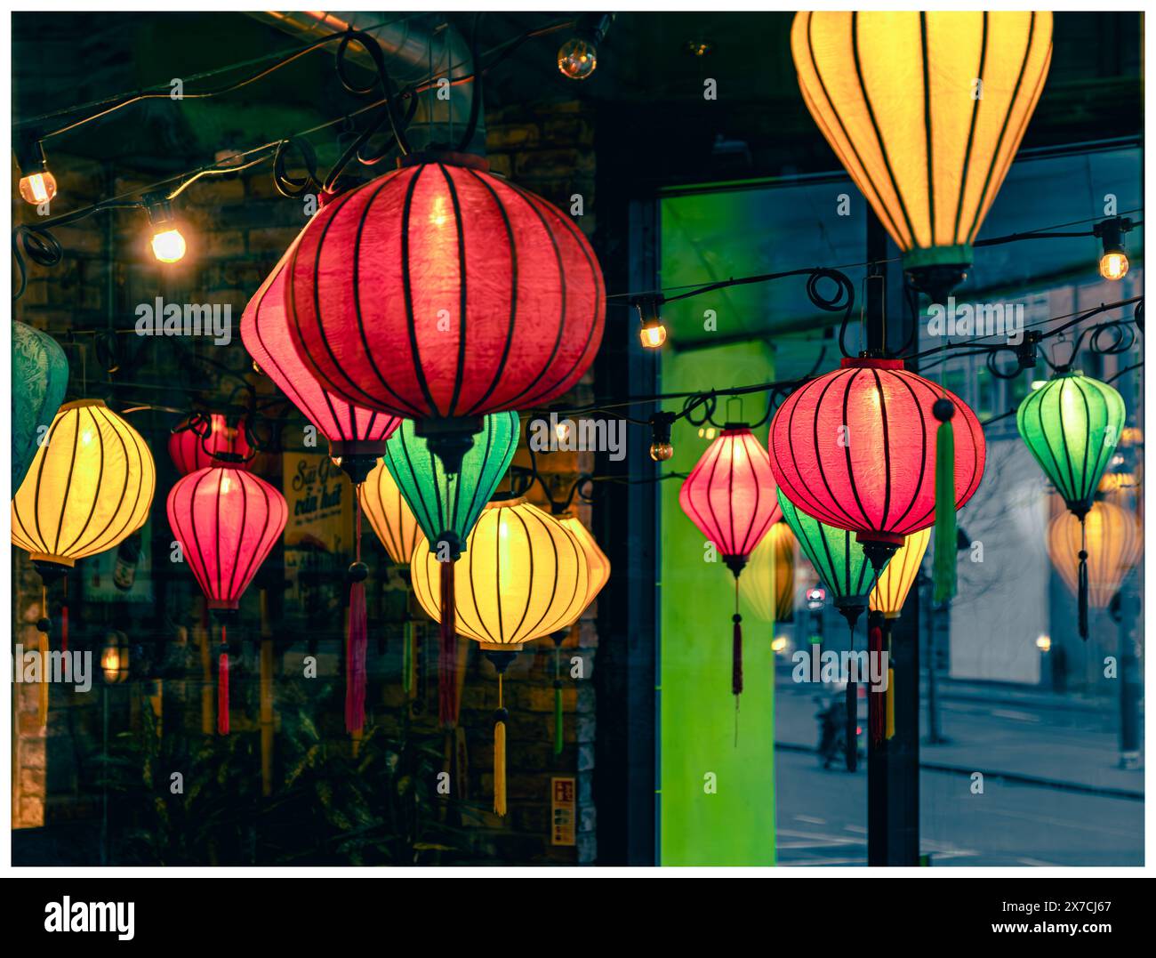 Lanternes colorées de style chinois suspendues dans un restaurant et vues à travers la fenêtre vitrée et de l'autre côté Banque D'Images