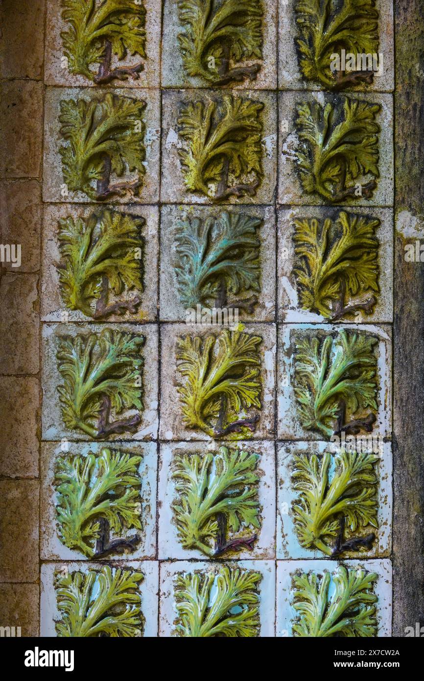 Les carreaux géométriques à motifs mauresques connus sous le nom d'Azulejos, décorent la façade à l'intérieur de l'arc du Triton menant à la cour des arches du palais de Pena ou au château historique de Palácio da Pena à Sintra, au Portugal. Le palais du château de conte de fées est considéré comme l'un des plus beaux exemples de l'architecture du romantisme portugais du 19ème siècle dans le monde. Banque D'Images