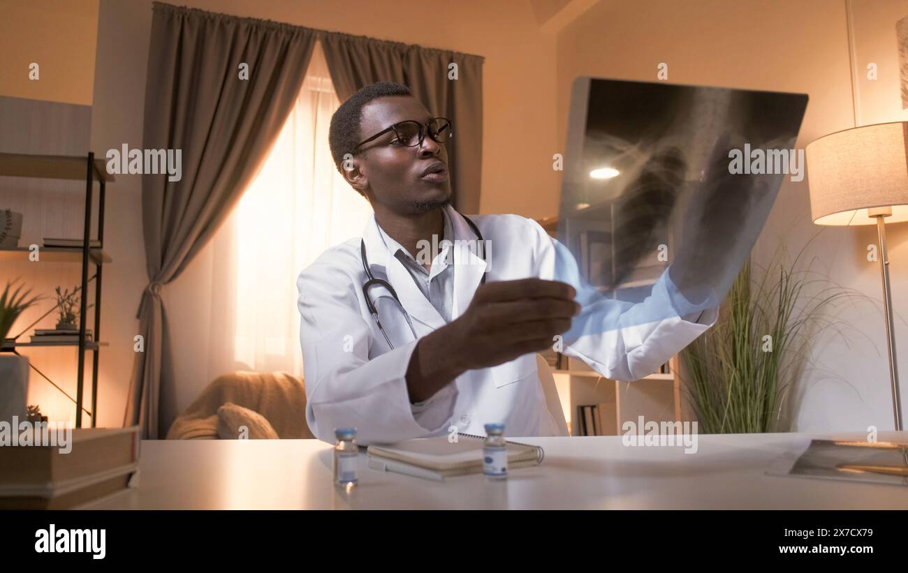 Diagnostic pulmonaire. Examen radiologique. Pneumonie Covid-19. Médecin masculin concerné qui étudie les radiographies thoraciques à l'intérieur d'une clinique moderne avec espace de copie. Banque D'Images