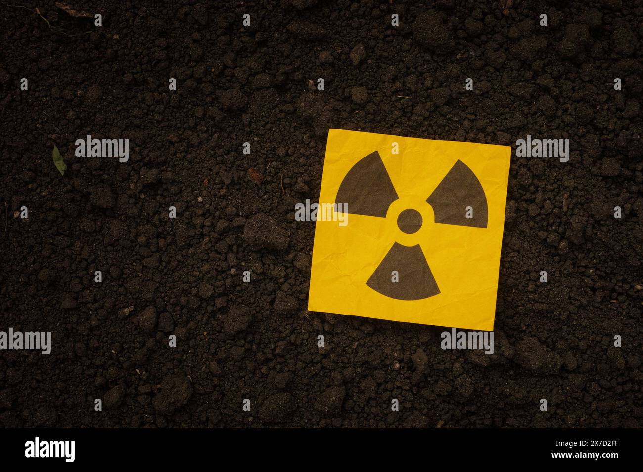 Un panneau d'avertissement de radiation sur un fond de sol. Gros plan. Banque D'Images