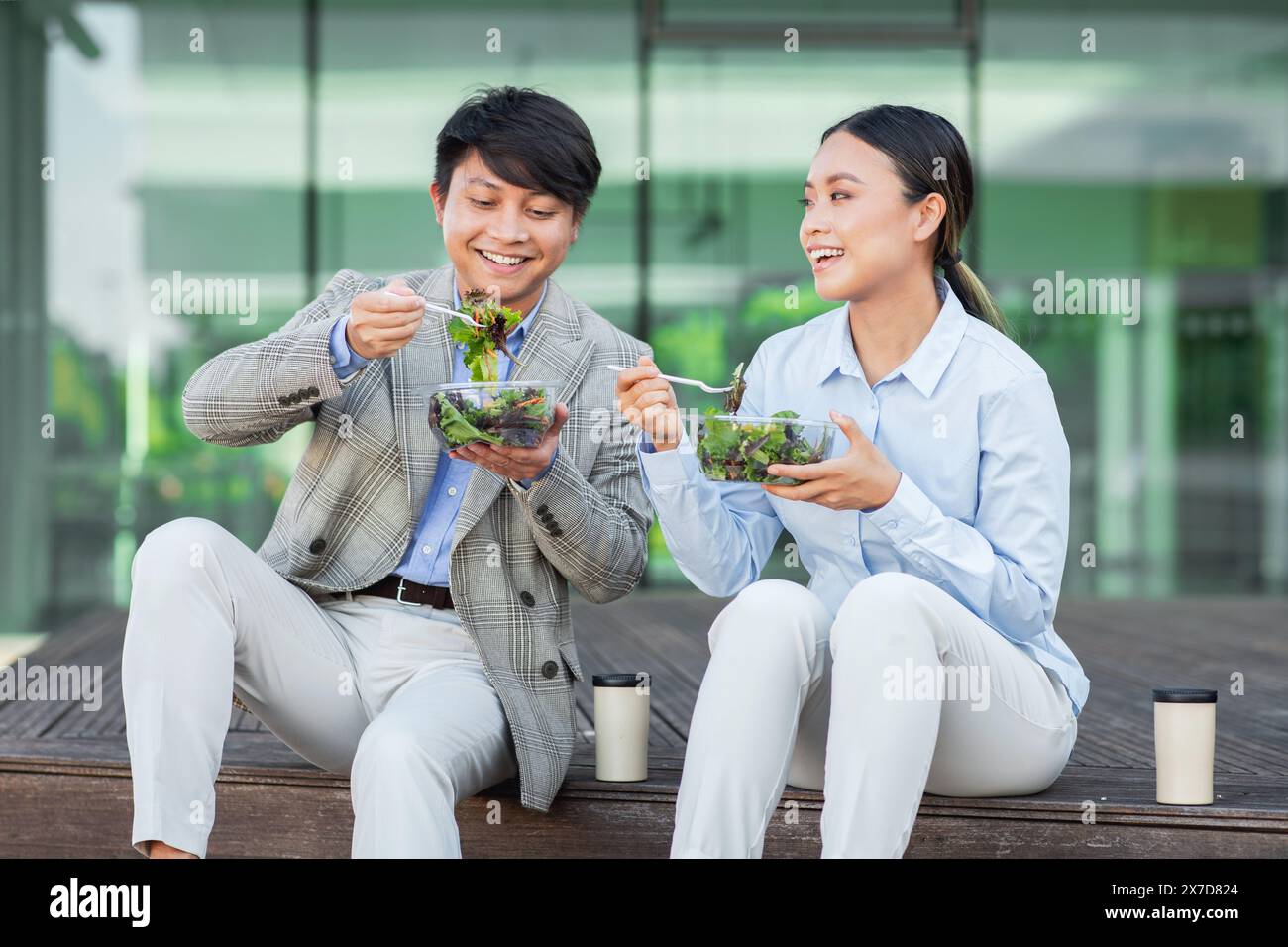 Deux hommes d'affaires asiatiques mangeant une salade Banque D'Images