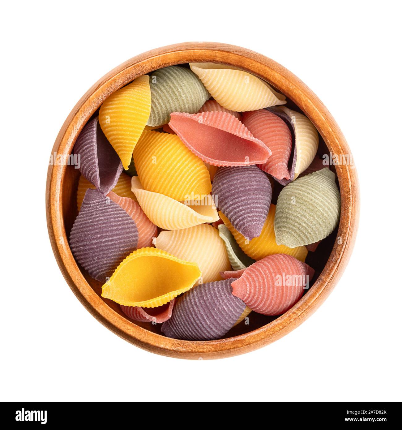 Conchiglie cinq couleurs, pâtes italiennes dans un bol en bois. Pâtes rondes, en forme de coquille et sillonnées, non cuites à la semoule de blé dur. Banque D'Images
