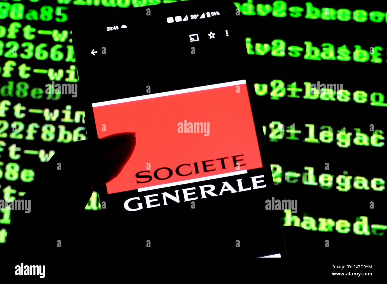 Dans cette illustration photo, un logo de Société générale vu affiché sur un smartphone avec des lignes de code en cours d'exécution en arrière-plan. Banque D'Images