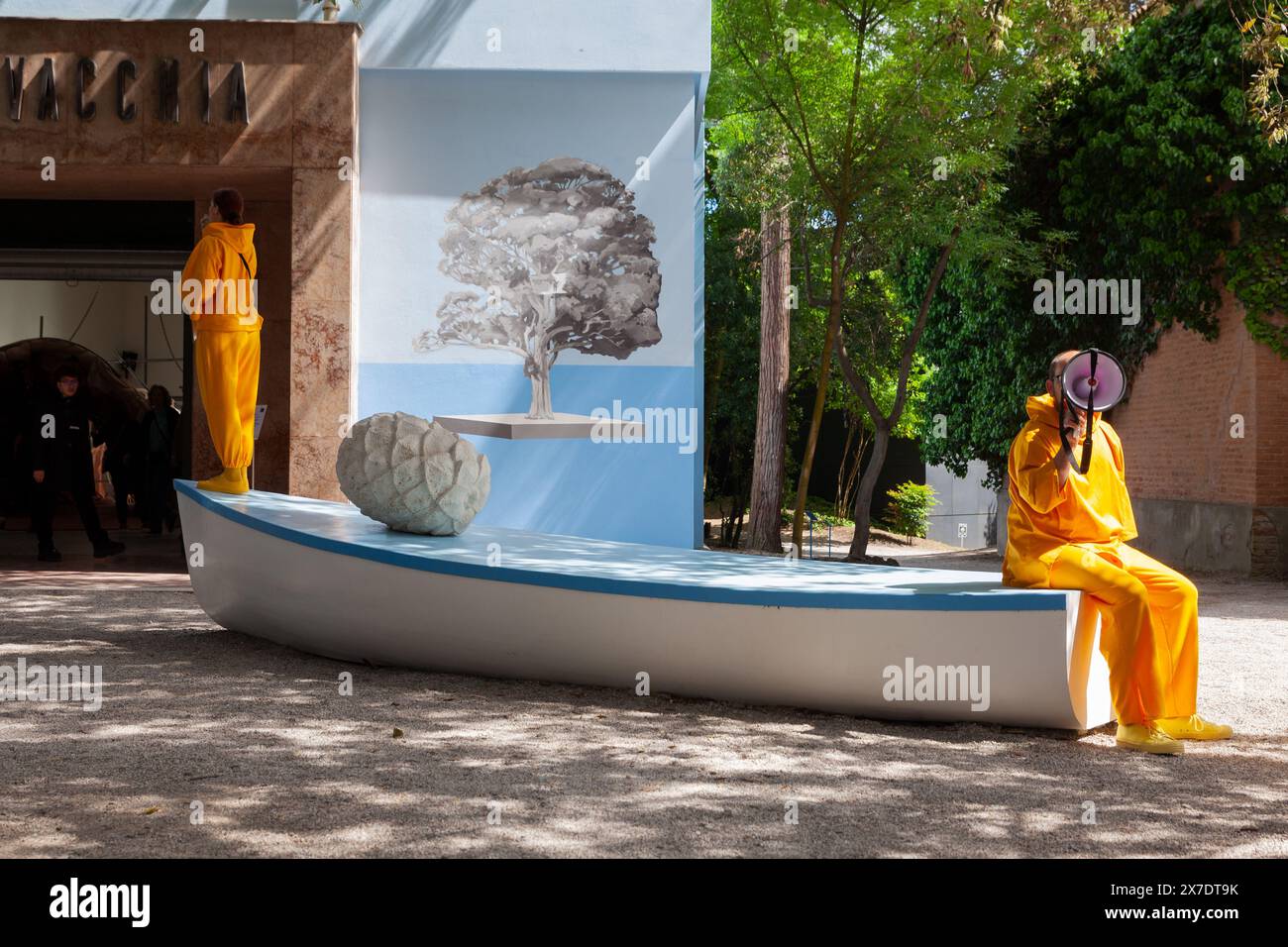 Venise, Italie - 20 avril 2024 : vue d'acteurs en combinaisons orange et mégaphone au Giardini lors de l'ouverture de la 60e Biennale de Venise Banque D'Images