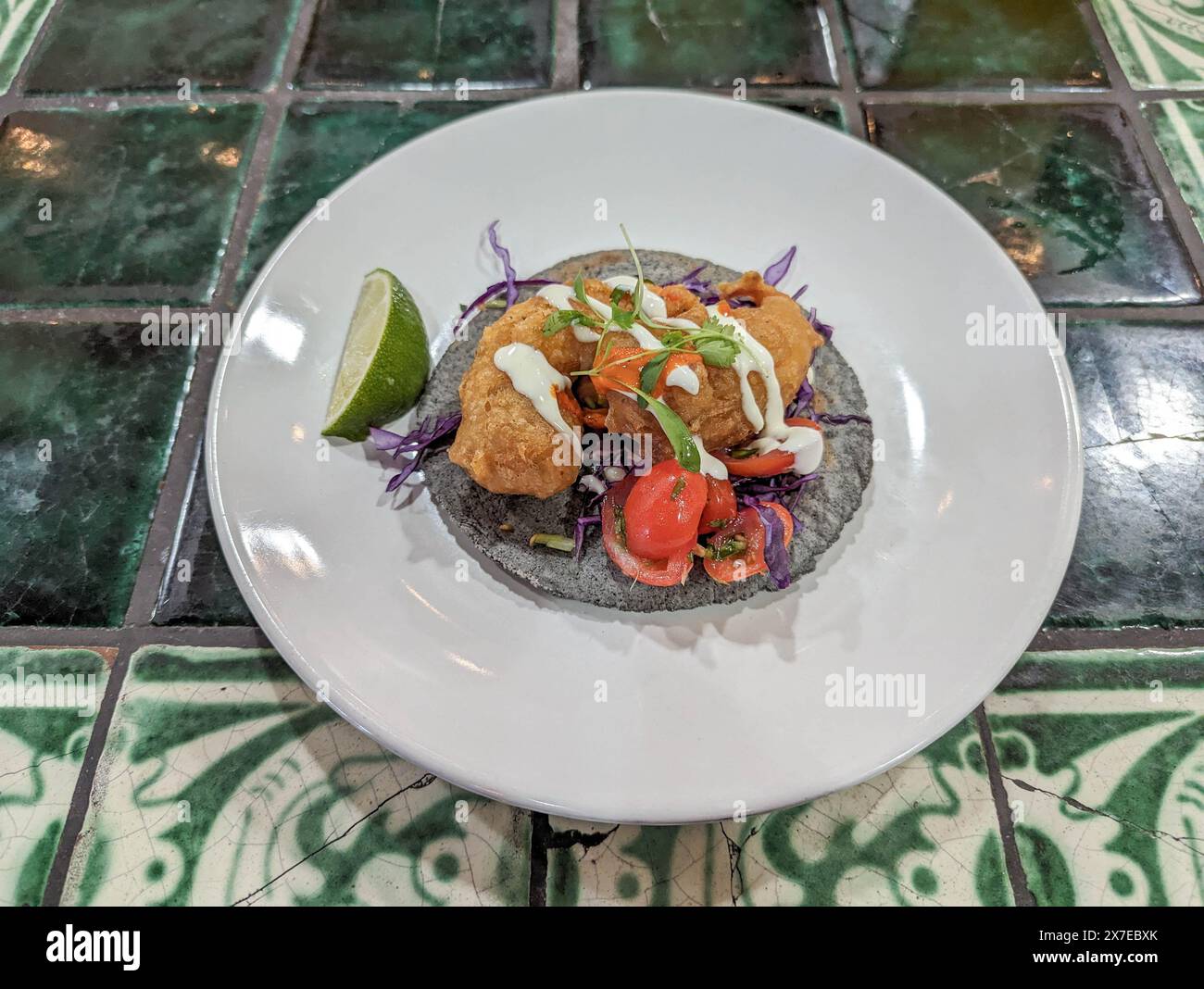 Un taco de crevettes tortilla de maïs bleu gourmand avec un citron vert sur le côté. Banque D'Images