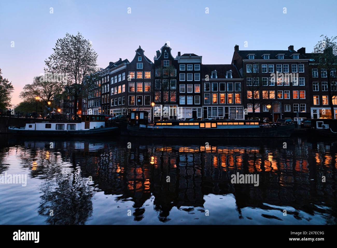 Pays-Bas, Amsterdam - 08 avril 2024 : maisons de canal d'Amsterdam, vélos et pont dans le quartier Jordaan au crépuscule Banque D'Images