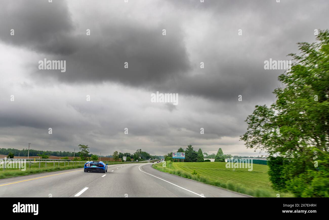 une lamborghini bleue qui accélère sur une autoroute à deux voies Banque D'Images