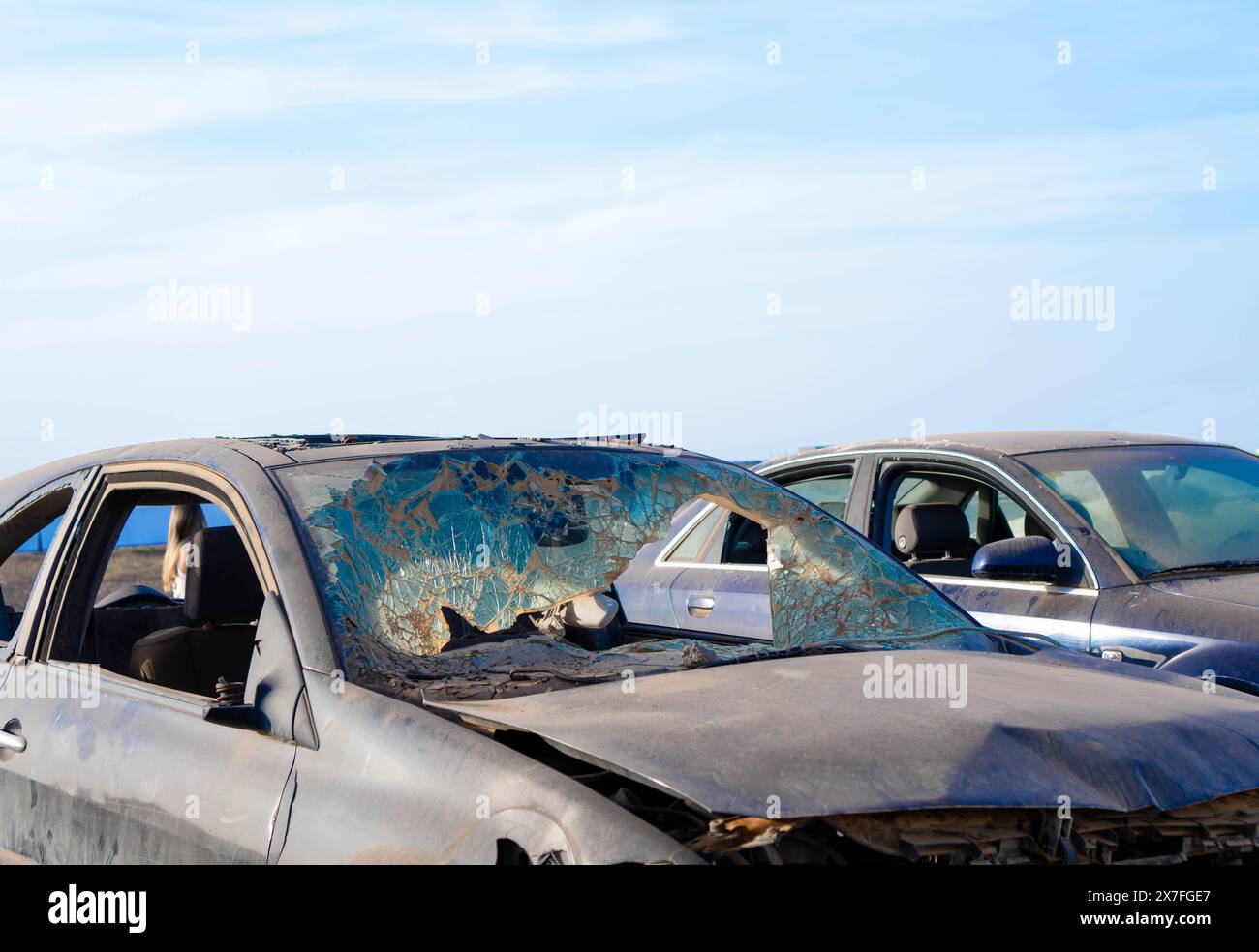 Deux voitures, abandonnées après une collision, sont lourdement endommagées avec des cadres bosselés et des fenêtres brisées. Banque D'Images