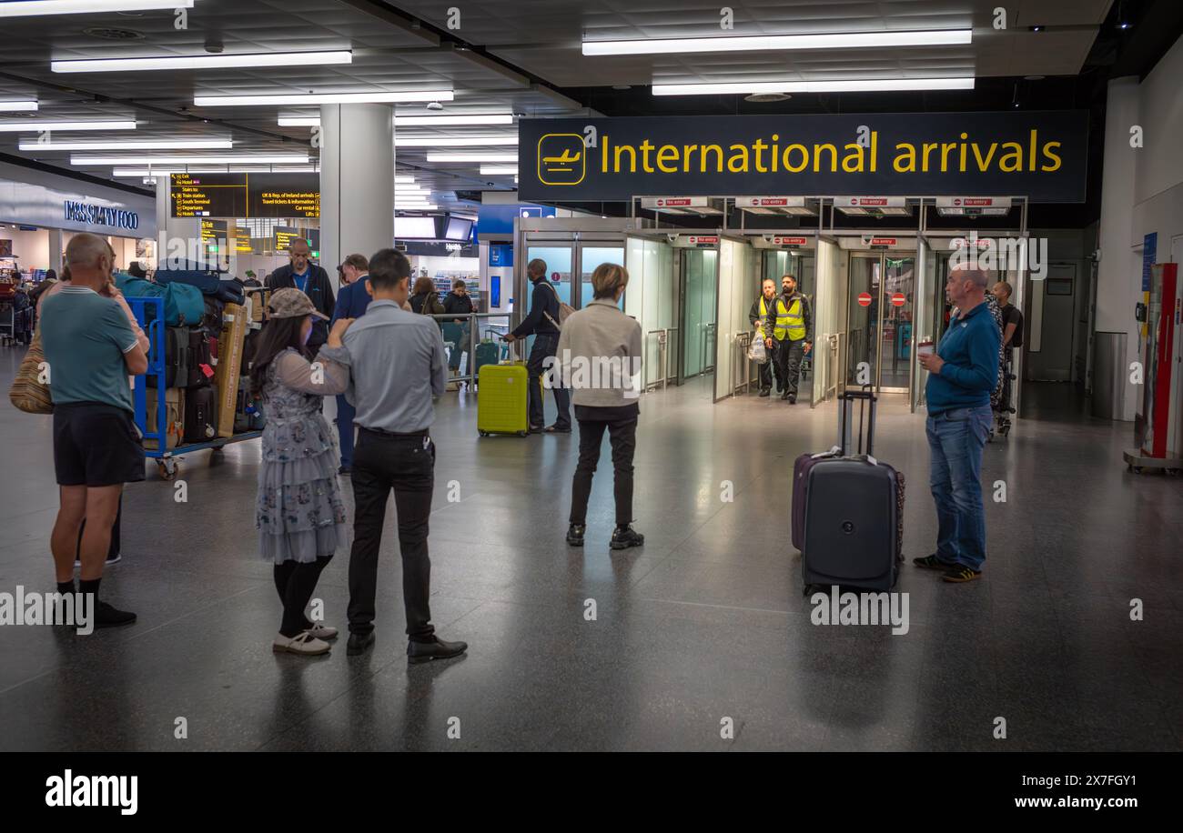 Les passagers attendent que les passagers aériens arrivent aux arrivées internationales au terminal nord de l'aéroport de Londres Gatwick, au Royaume-Uni. Banque D'Images