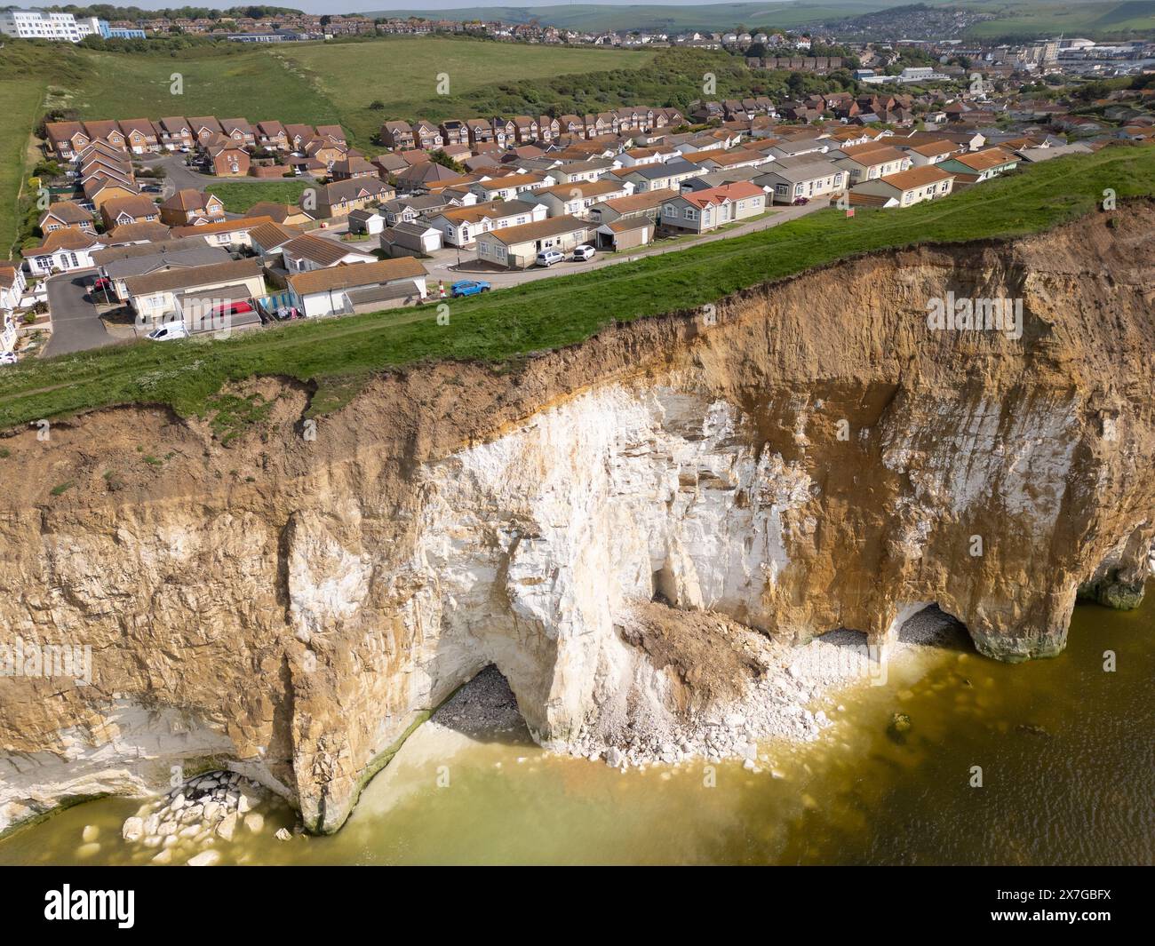 Newhaven, East Sussex, Royaume-Uni. 20 mai 2024. Une énorme section de falaise est tombée dans la mer hier avec d'autres chutes de pierres atterrissant la nuit sur la plage. La chute de falaise de craie est à quelques mètres de Newhaven Heights, un parc de mobil-homes pour les plus de 50 ans Les résidents sont maintenant précaires près du bord de la falaise et suggèrent qu'il ne faudra pas longtemps avant que le sentier côtier et les maisons près de la falaise devront être abandonnés. Pendant ce temps, la plage ci-dessous a des affleurements de roche de craie qui pendent précairement au-dessus. Crédit : Reppans/Alamy Live News Banque D'Images