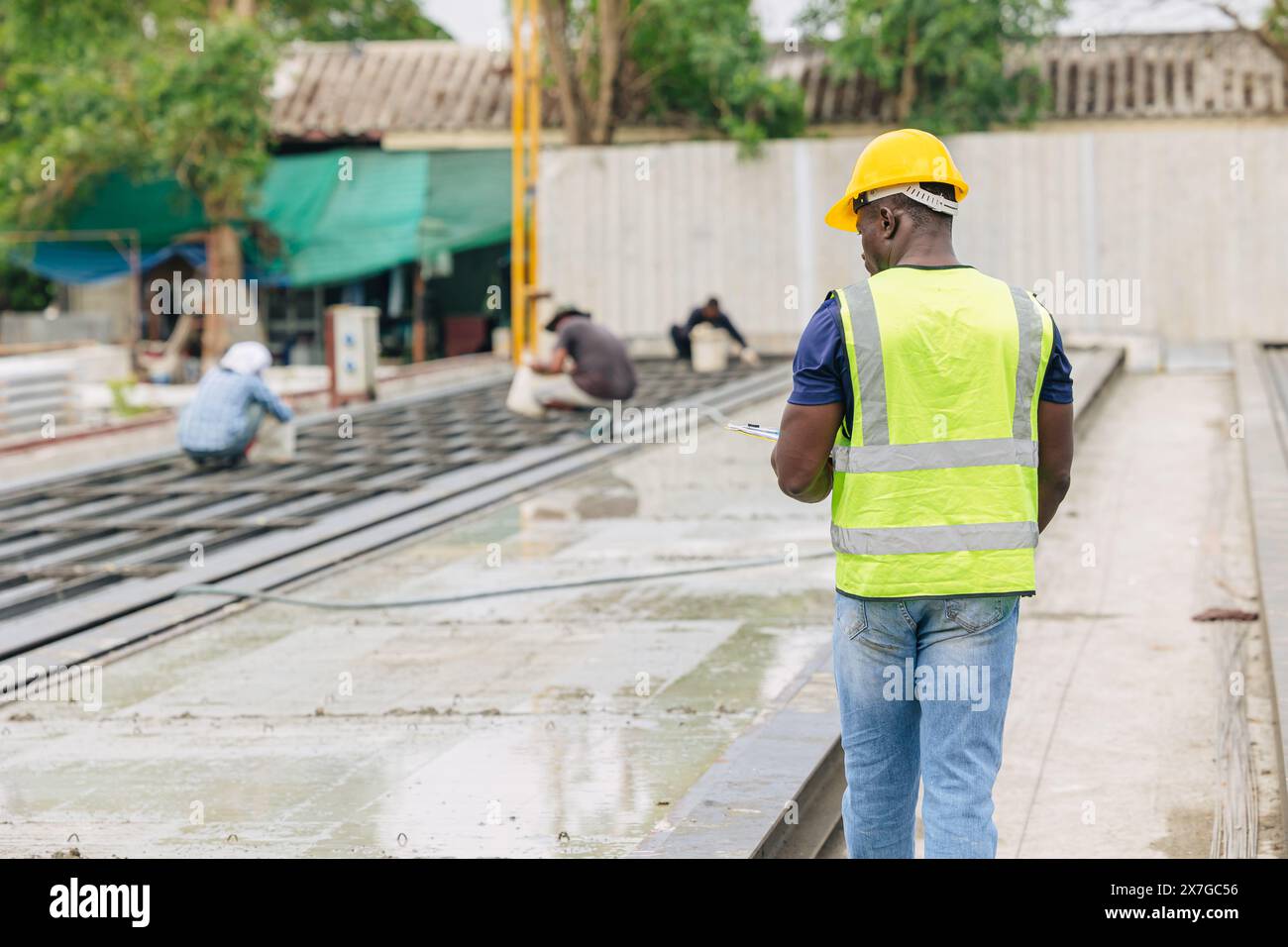 Ingénieur contrôle de qualité dans la fabrication de moulage de béton préfabriqué vérifiant les produits de qualité standard site de construction extérieur, travailleur noir africain Banque D'Images