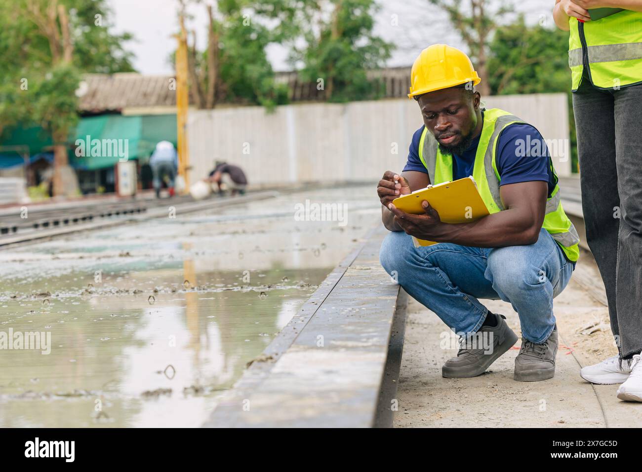 Ingénieur contrôle de qualité dans la fabrication de moulage de béton préfabriqué vérifiant les produits de qualité standard site de construction extérieur, travailleur noir africain Banque D'Images