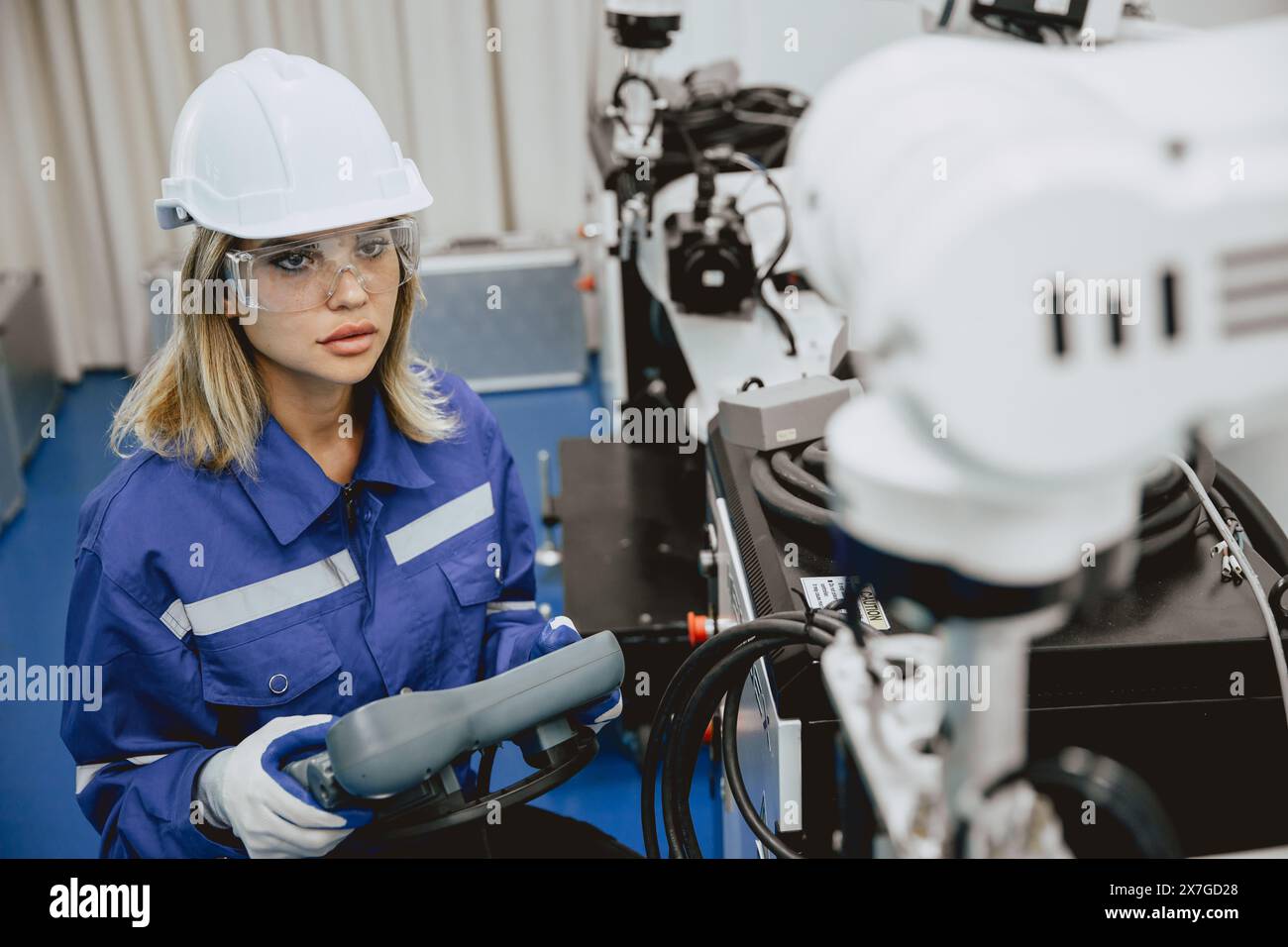 Ingénieur étudiante universitaire étudiante apprendre à la main manuelle actionner le bras robotisé de l'industrie avec la télécommande dans la salle de classe de laboratoire d'ingénieurs robotiques dans polytechn Banque D'Images
