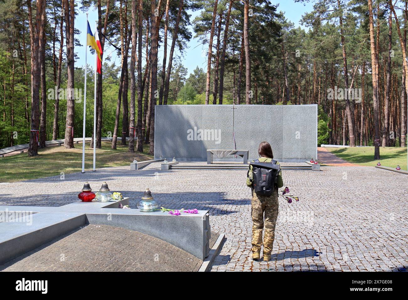 Non exclusif : KIEV, UKRAINE - 19 MAI 2024 - Une femme de service face au mémorial du cimetière militaire polonais à l'Histor national des graves de Bykivnia Banque D'Images