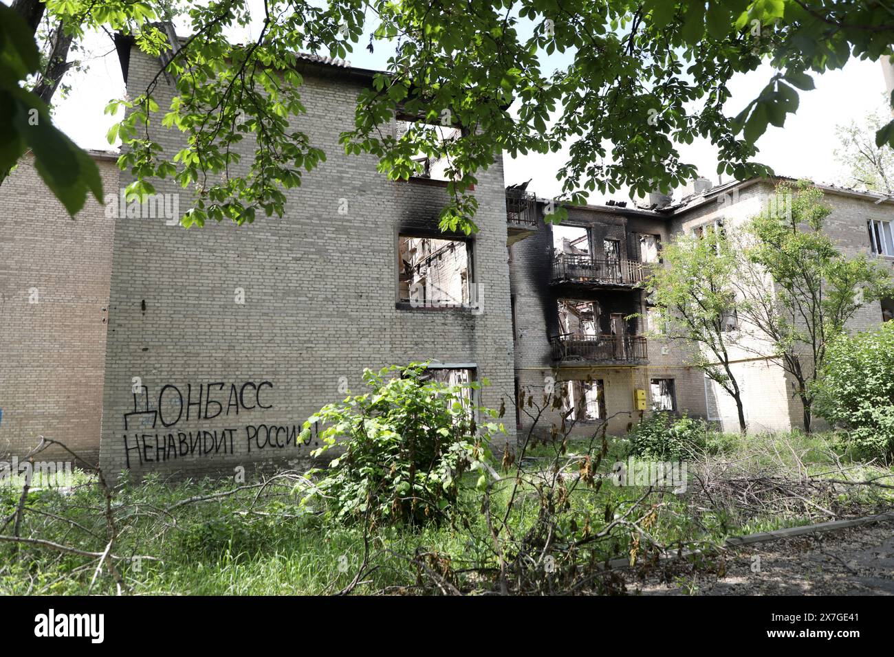 CHASIV YAR, UKRAINE - 18 MAI 2024 - L'inscription en russe  qt Donbass déteste la Russie!» Est vu sur un immeuble endommagé par des bombardements russes, Chasiv Yar, région de Donetsk, est de l'Ukraine. Banque D'Images