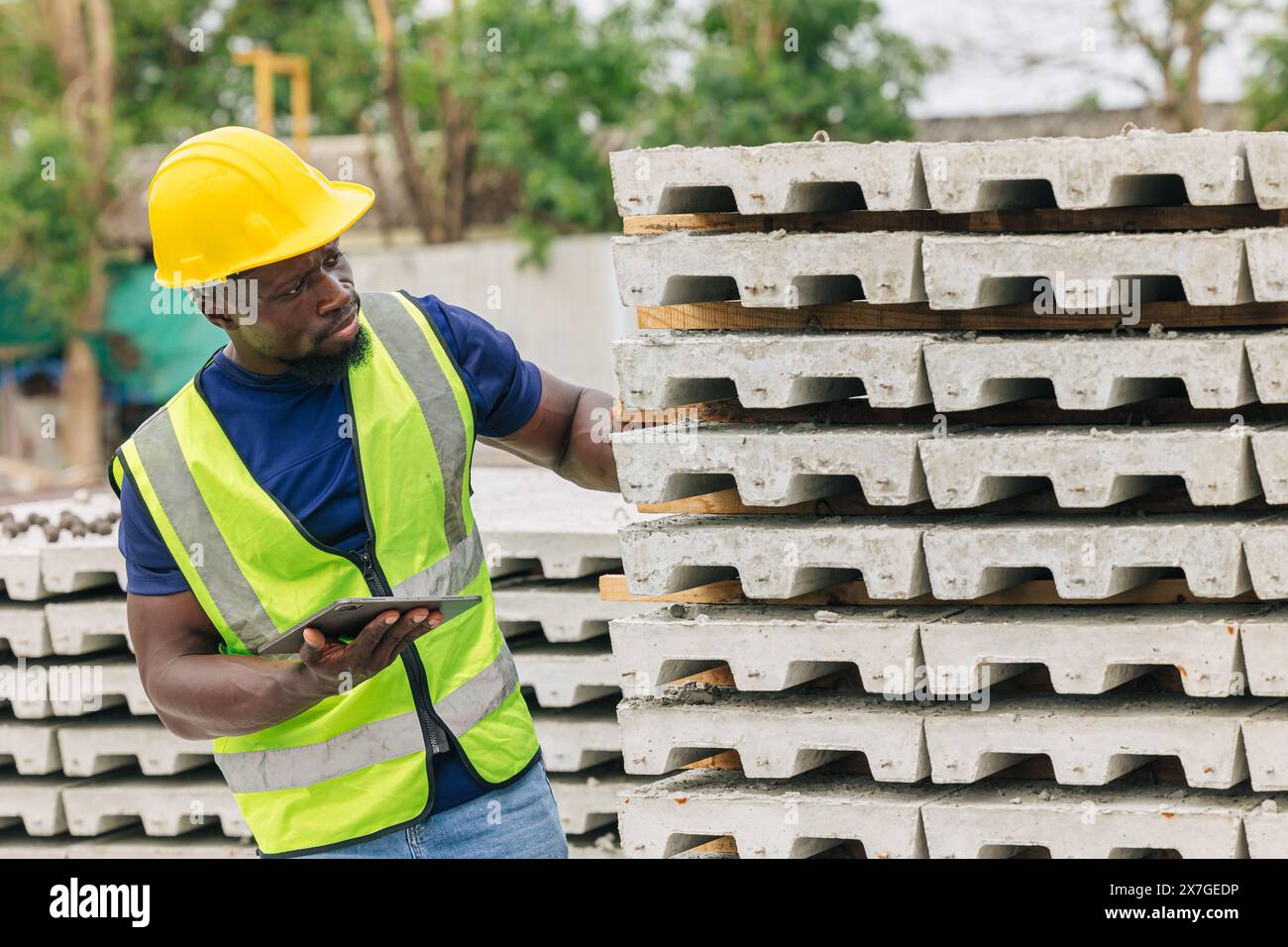 Ingénieur contrôle de qualité dans la fabrication de moulage de béton préfabriqué vérifiant les produits de qualité standard site de construction extérieur, travailleur noir africain Banque D'Images