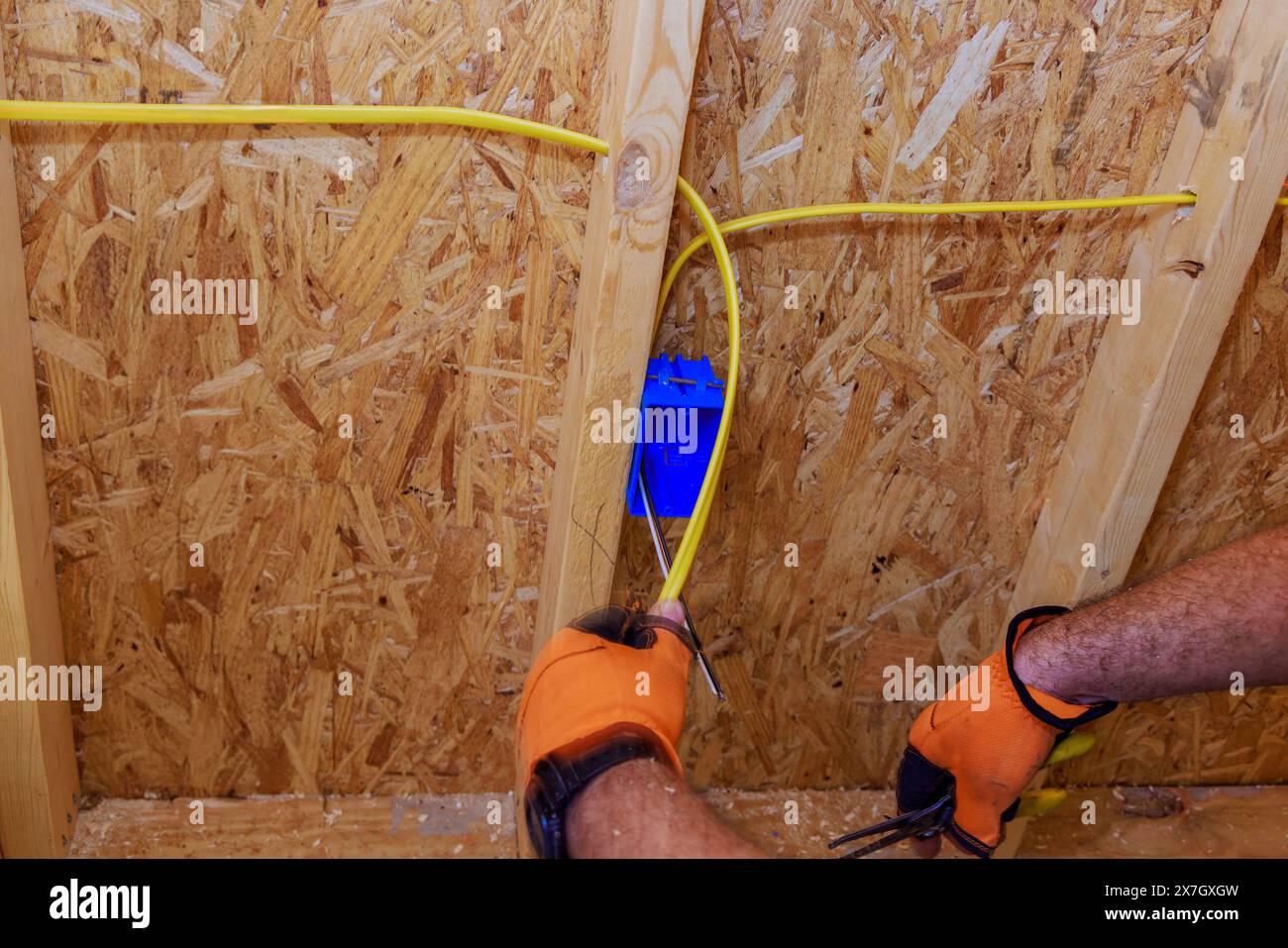 Installation de fils électriques par un électricien sur un chantier de construction résidentiel Banque D'Images