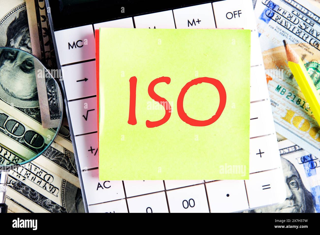 ISO. Organisation internationale de normalisation. Un mot ISO sur l'autocollant jaune sur la calculatrice sur le fond de dollars Banque D'Images