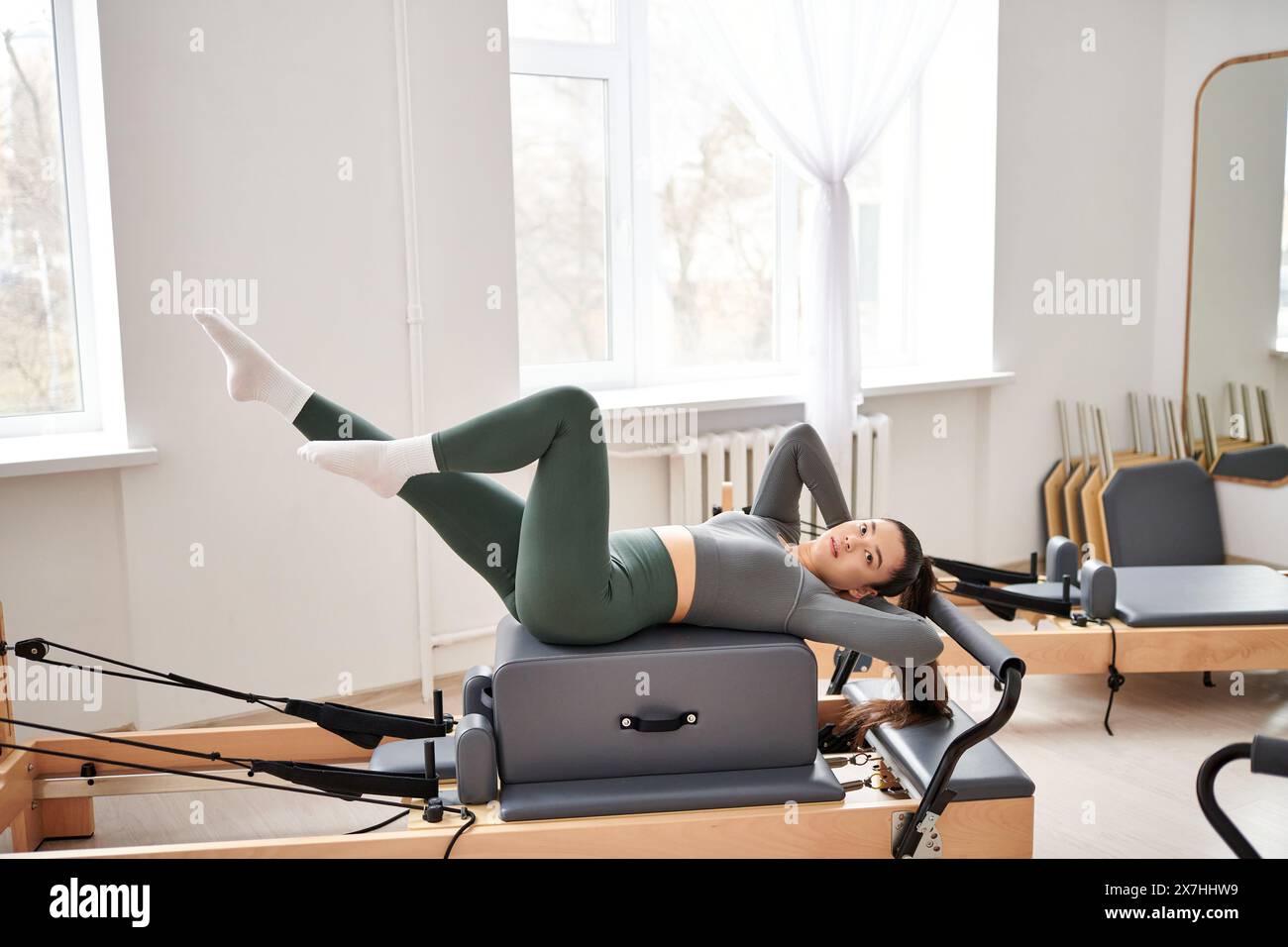 Femme athlétique dans une tenue confortable exerçant activement sur la leçon de pilates. Banque D'Images