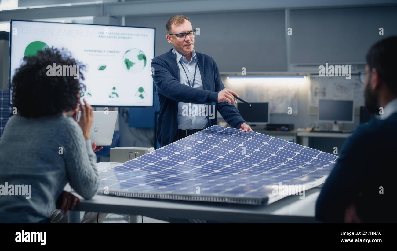 L'ingénieur en chef pointe sur projection Screen et parle des possibilités futures d'énergie verte et de panneaux solaires. Ingénierie et énergie durable concept d'enseignement supérieur. Banque D'Images