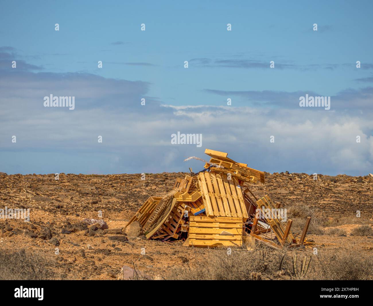 palettes en bois utilisées et vieille table empilées sur le paysage de campagne basculant à la mouche pour un feu de joie Banque D'Images