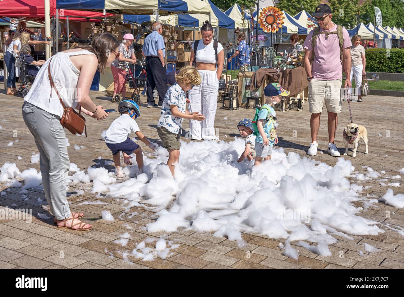 Enfants jouant dans des bulles de mousse à l'extérieur. Stratford upon Avon, Angleterre, Royaume-Uni. Les enfants s'amusent à l'extérieur Banque D'Images