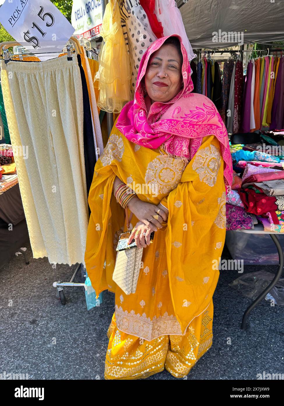 Une femme bangladaise vêtue de couleurs vives pose pour une photo à la foire de rue bangladaise dans le quartier de Kensington à Brooklyn, NY Banque D'Images