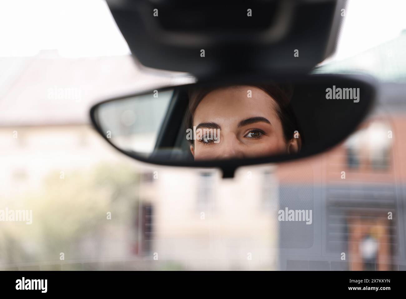 Femme conduisant sa voiture, reflet dans le rétroviseur Banque D'Images