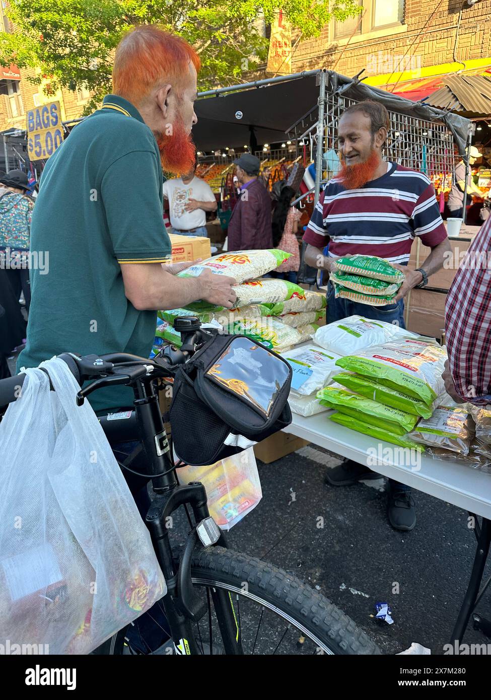 Hommes avec des barbes et des cheveux colorés au henné faisant des affaires à la foire de rue du Bangladesh dans la section de Kensington de Brooklyn, New Y Banque D'Images