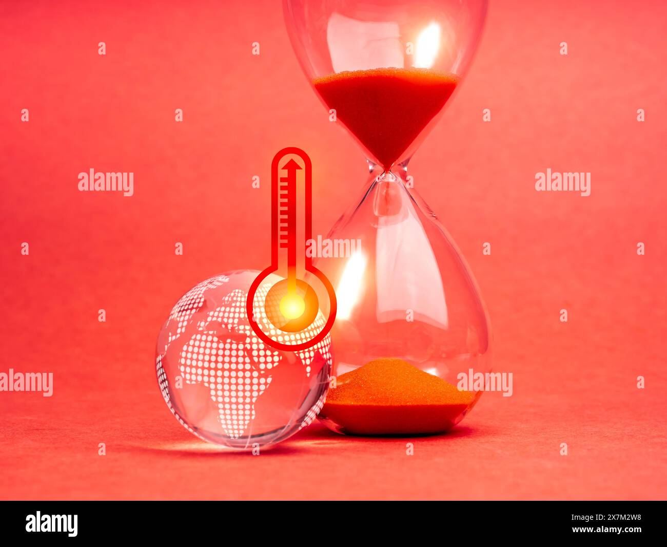 Concept de réchauffement climatique et de changement climatique. Thermomètre temps chaud avec flèche sur le symbole de haute température sur le globe de terre de verre et sablier sur le bac rouge Banque D'Images