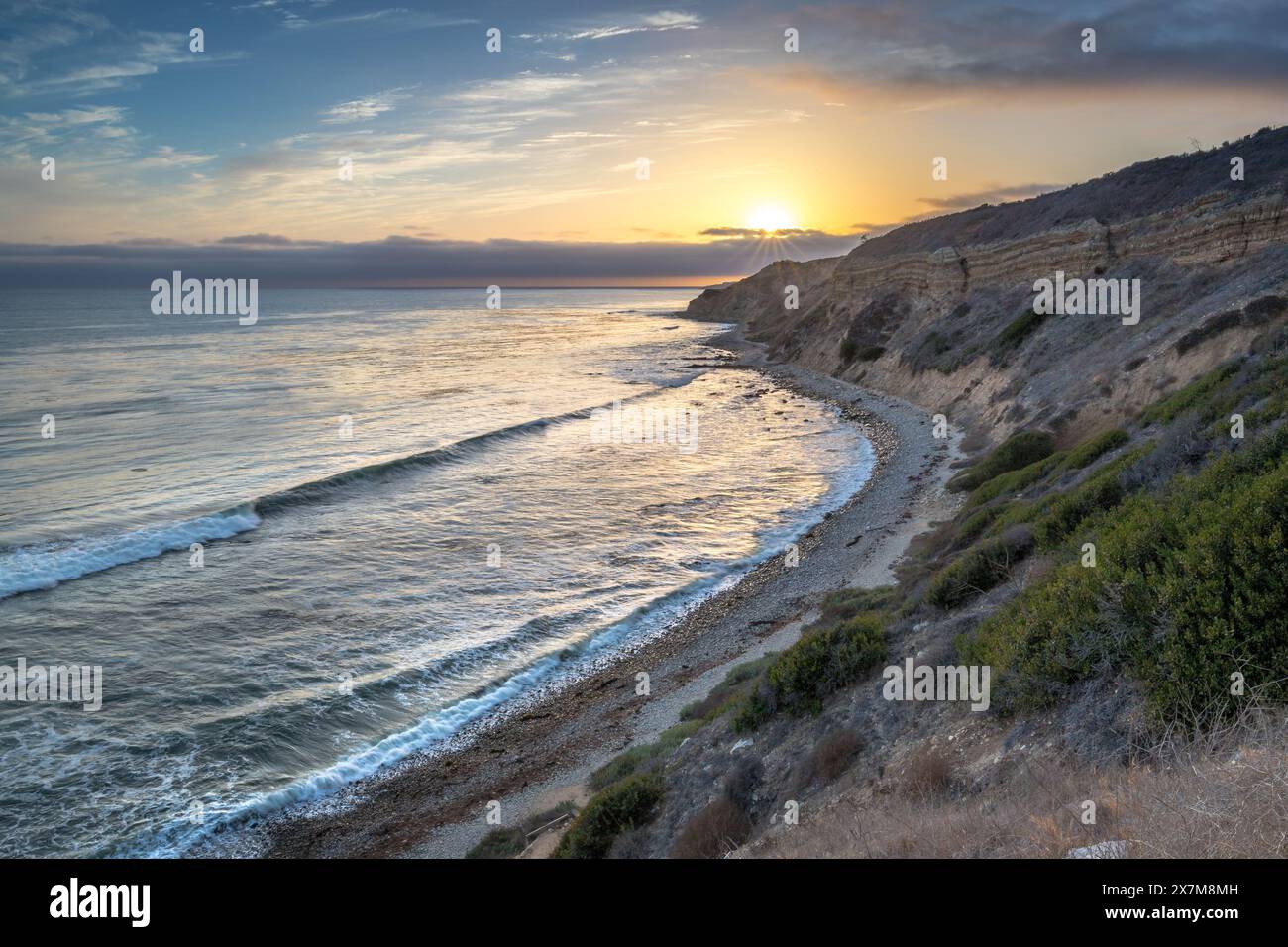 Embarquez pour un voyage serein le long du Catalina Trail, où le coucher de soleil paisible illumine les falaises accidentées et la splendeur côtière de Ocean Trails Rese Banque D'Images