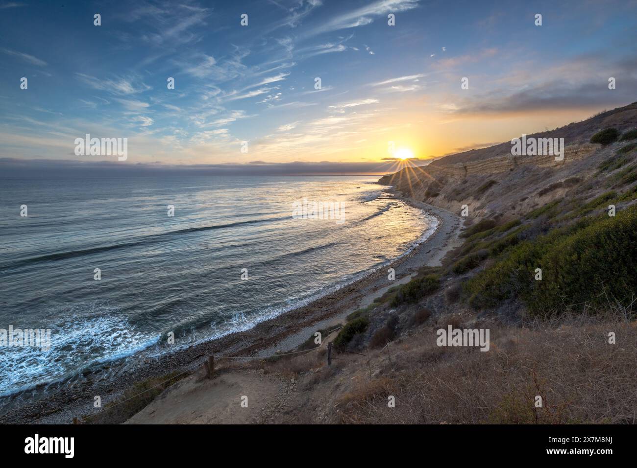 Embarquez pour un voyage serein le long du Catalina Trail, où le coucher de soleil paisible illumine les falaises accidentées et la splendeur côtière de Ocean Trails Rese Banque D'Images