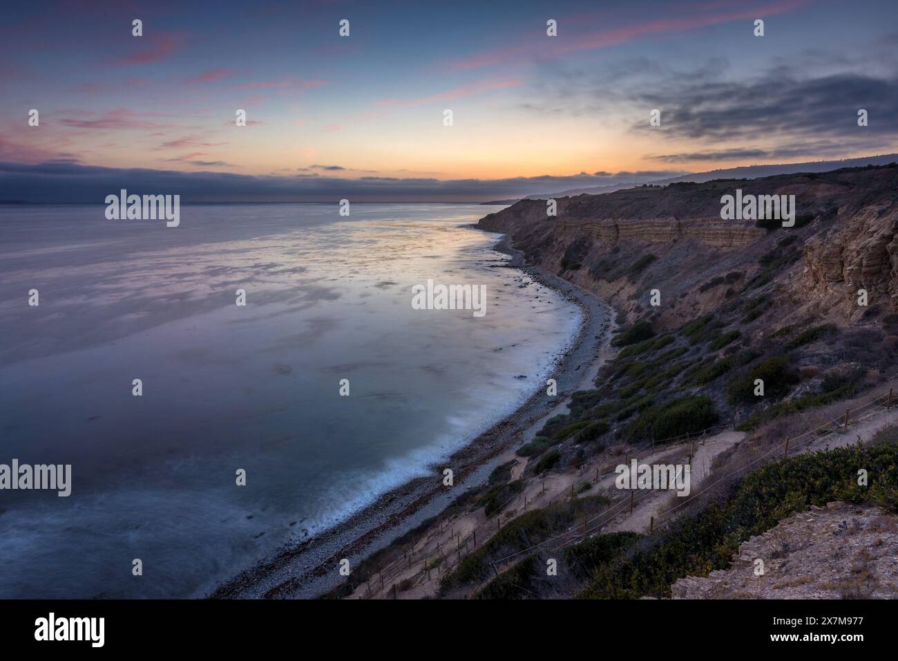 Embarquez pour un voyage serein le long du Catalina Trail, où le coucher de soleil paisible illumine les falaises accidentées et la splendeur côtière de Ocean Trails Rese Banque D'Images