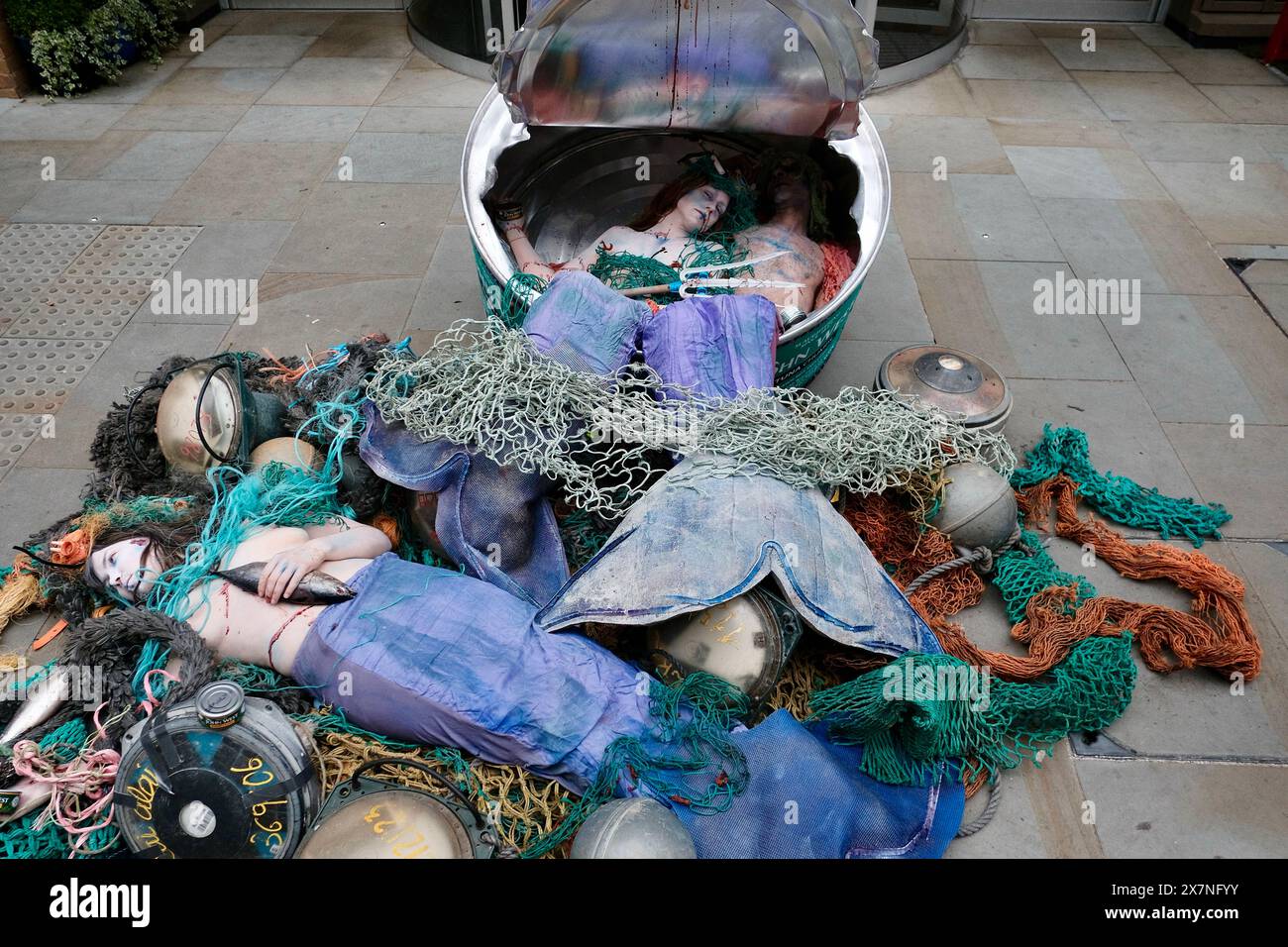 Londres, Angleterre, Royaume-Uni. 21 mai 2024. Ocean Rebellion, un groupe de militants écologistes, organise une protestation dramatique contre John West Tuna lors du Blue Food innovation Summit. Une boîte géante étiquetée ''˜JOHN WEST, THONOT CHUMPS' est déchirée, révélant ''˜prise accidentelle' de merveilles ensanglantées, symbolisant les victimes involontaires des pratiques de pêche industrielle. La manifestation met en lumière l'utilisation controversée de dispositifs d'agrégation de poissons dérivants (dFAD) par des pêcheries provenant de Thai Union, le propriétaire de John West. Crédit : ZUMA Press, Inc/Alamy Live News Banque D'Images