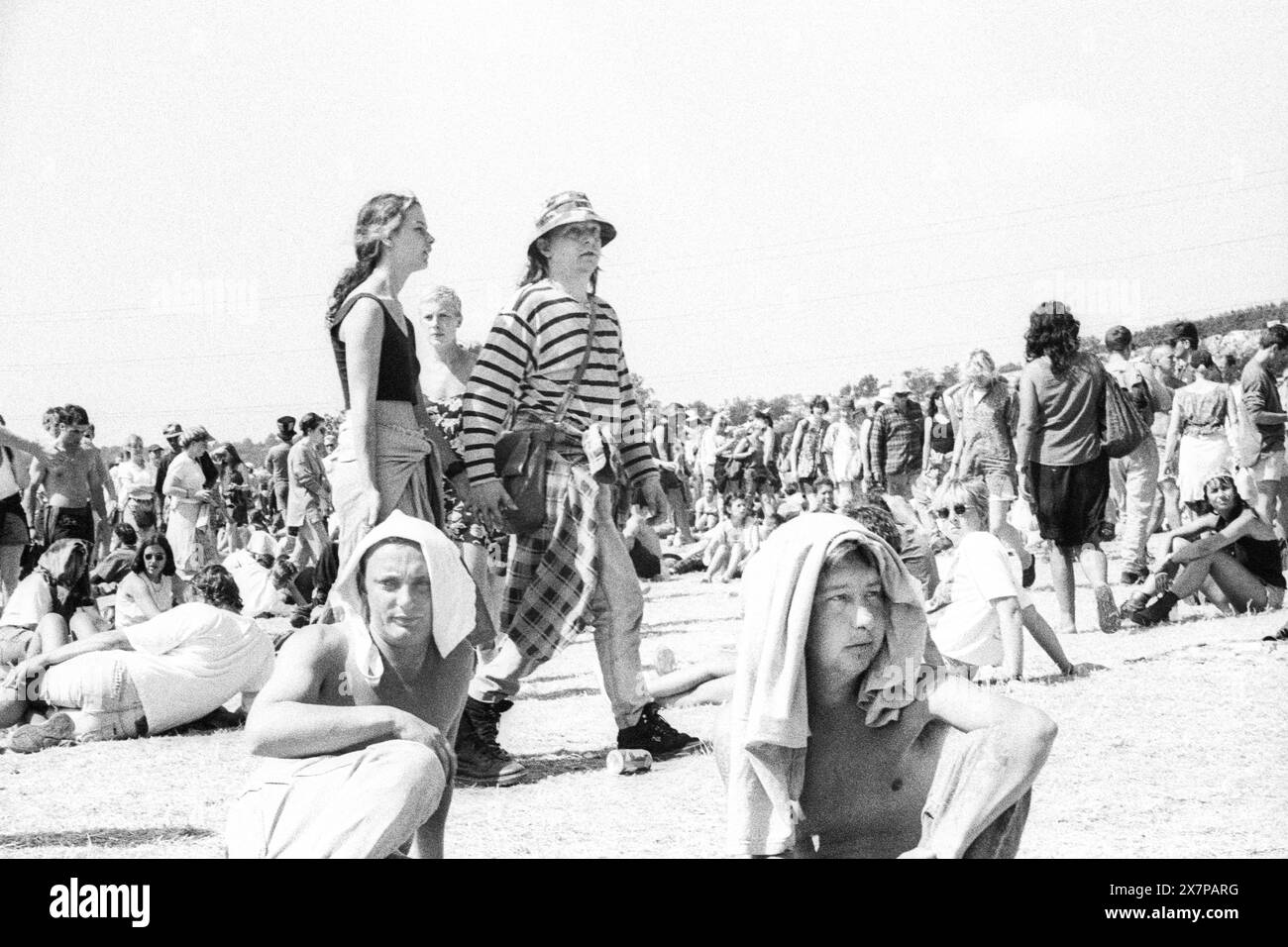 FOULE, CANICULE, SERVIETTE SUR LES TÊTES, SCÈNE NME, GLASTONBURY 95 : les festivaliers s'écrasent sur l'herbe avec des serviettes sur la tête dans la canicule estivale extrême au deuxième NME Stage Field et la foule au Glastonbury Festival, Pilton Farm, Somerset, Angleterre, 24 juin 1995. En 1995, le festival a célébré son 25e anniversaire. Beaucoup de gens ont lutté avec un coup de chaleur lors du week-end particulièrement chaud. Photo : ROB WATKINS Banque D'Images