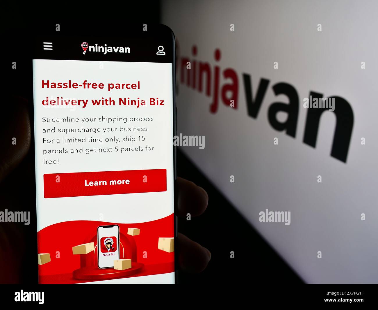 Personne tenant smartphone avec la page Web de la société de livraison singapourienne Ninja Logistics Pte. Ltd. avec logo. Concentrez-vous sur le centre de l'écran du téléphone. Banque D'Images